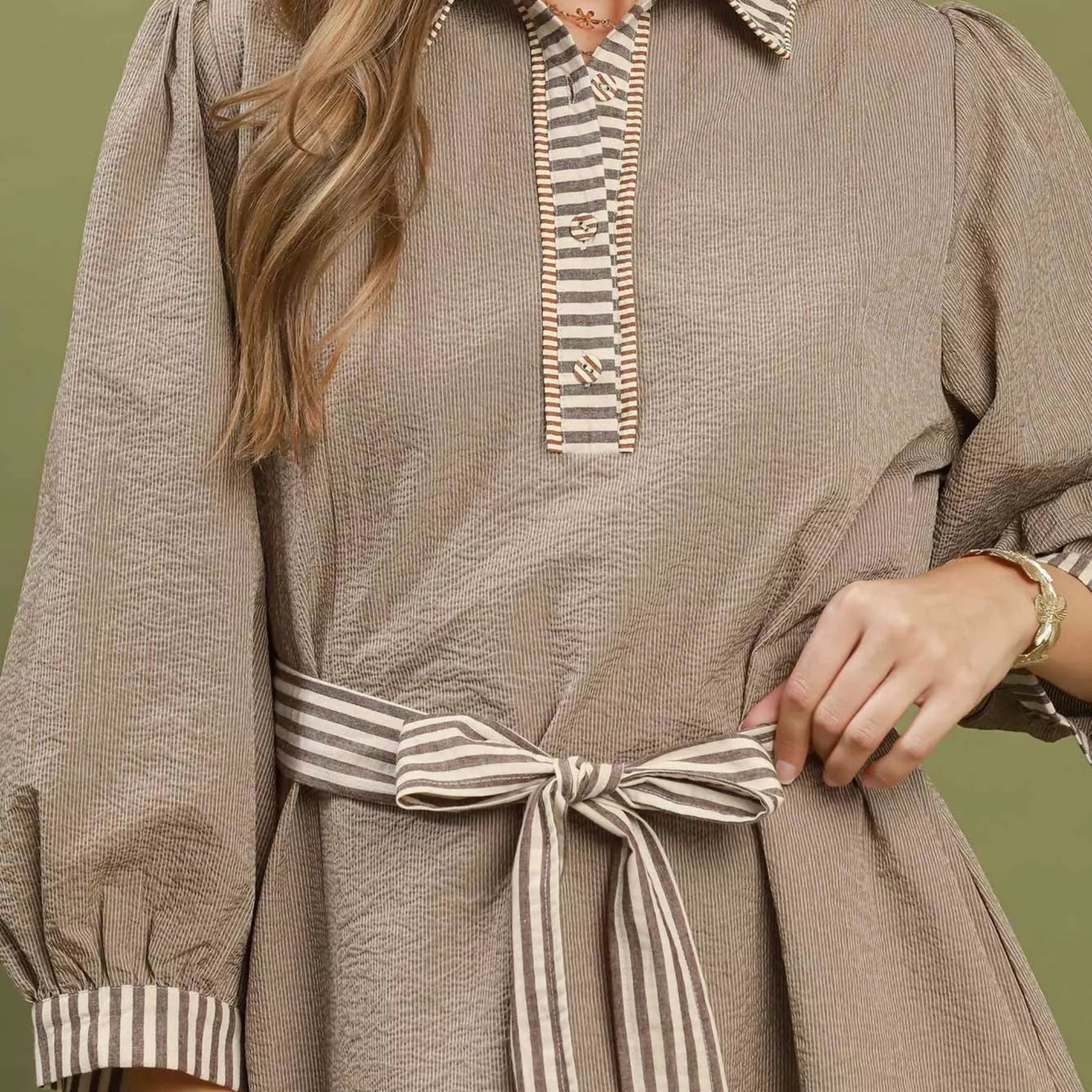 Close up shot of the elastic puff sleeve on a brown striped Umgee dress from Solazura Boutique