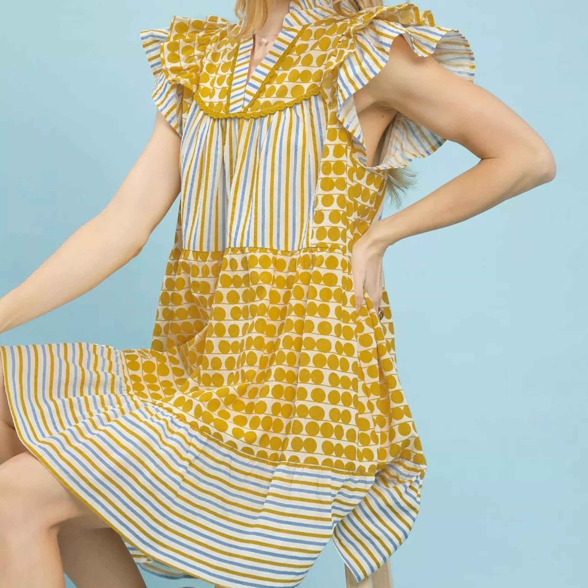 Model wearing a bohemian style Umgee mixed patchwork flutter sleeve dress from Solazura Boutique