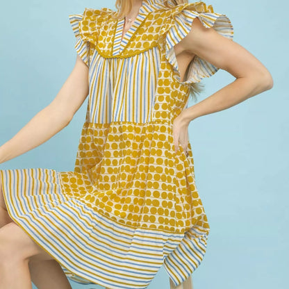 Model wearing a bohemian style Umgee mixed patchwork flutter sleeve dress from Solazura Boutique