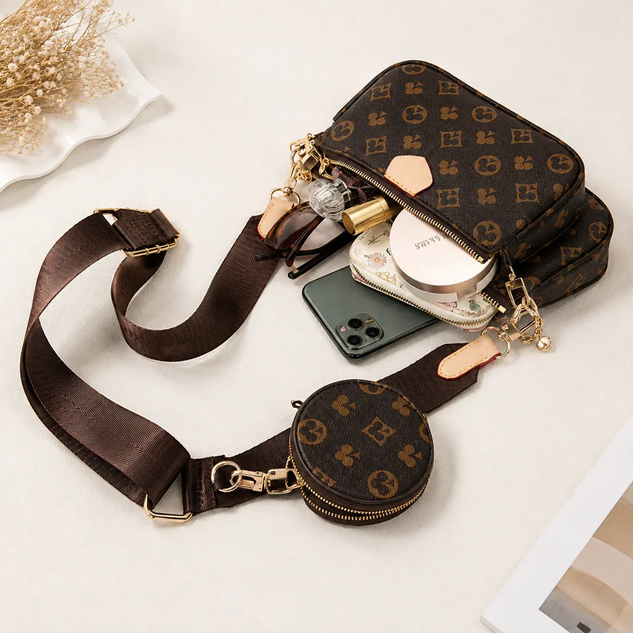 3-piece convertible brown crossbody handbag with detachable coin pouch and shoulder bag displayed with everyday essentials.