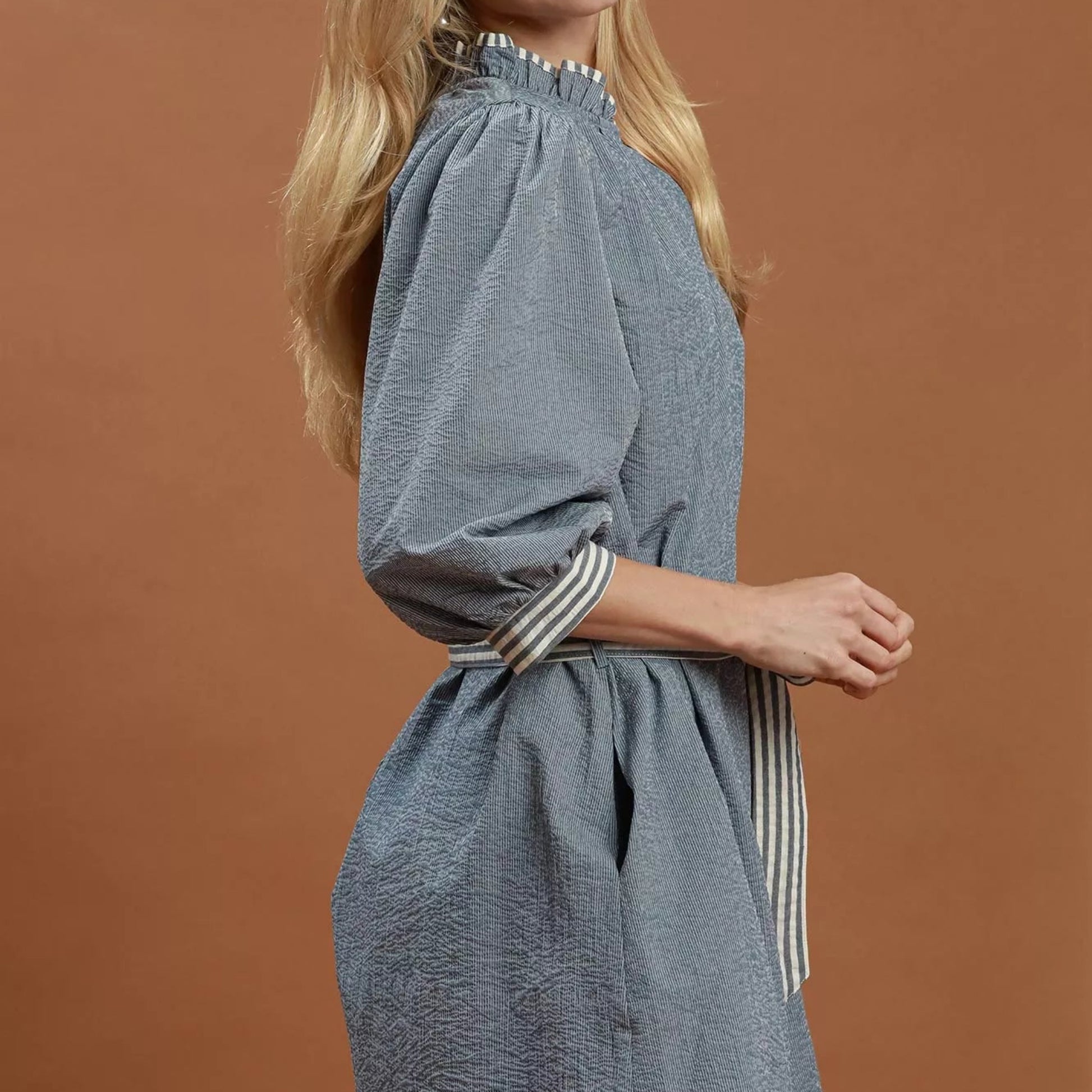 Model wearing a flattering denim Umgee contrast trim tie waist dress from Solazura Boutique