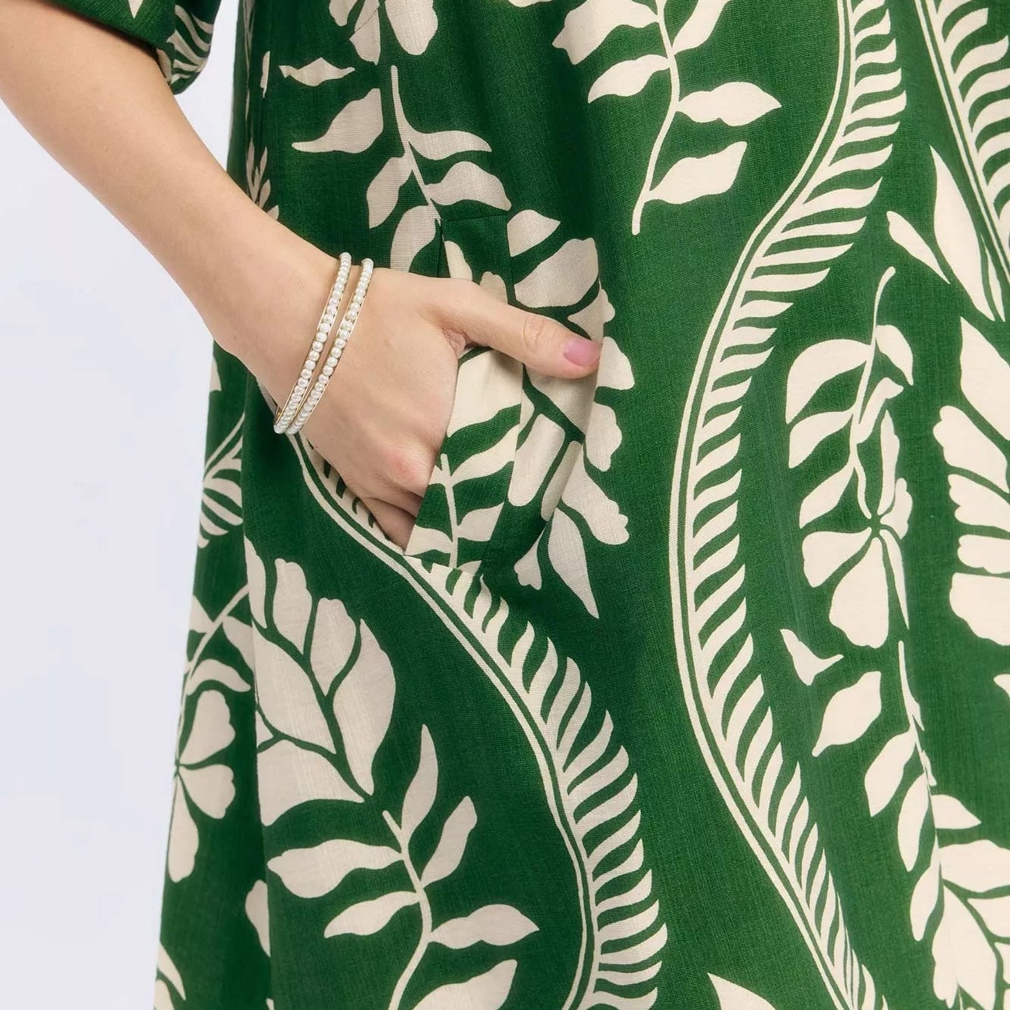 Chic summer vacation or resort outfit styling with a cream green leafy mini dress from Solazura Boutique
