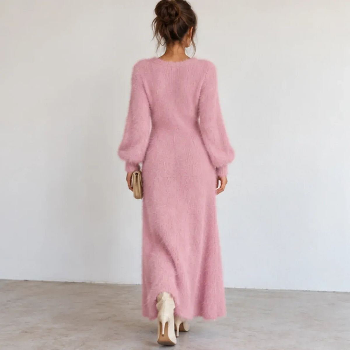 Back view of a pink fuzzy knit maxi dress with long sleeves and soft textured knit fabric.