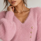 Close-up of pink fuzzy knit maxi dress showing the V-neckline, soft textured fabric, and gold button-side detail.