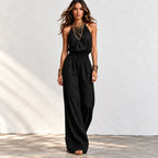 Back view of women’s khaki halter wide-leg linen jumpsuit with halter neck tie and smocked waist