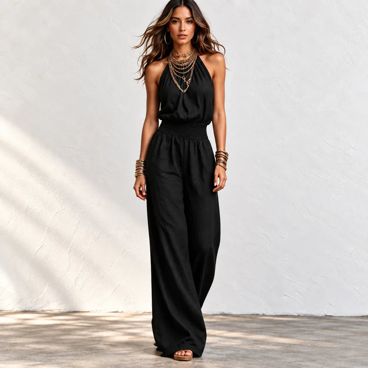 Back view of women’s khaki halter wide-leg linen jumpsuit with halter neck tie and smocked waist