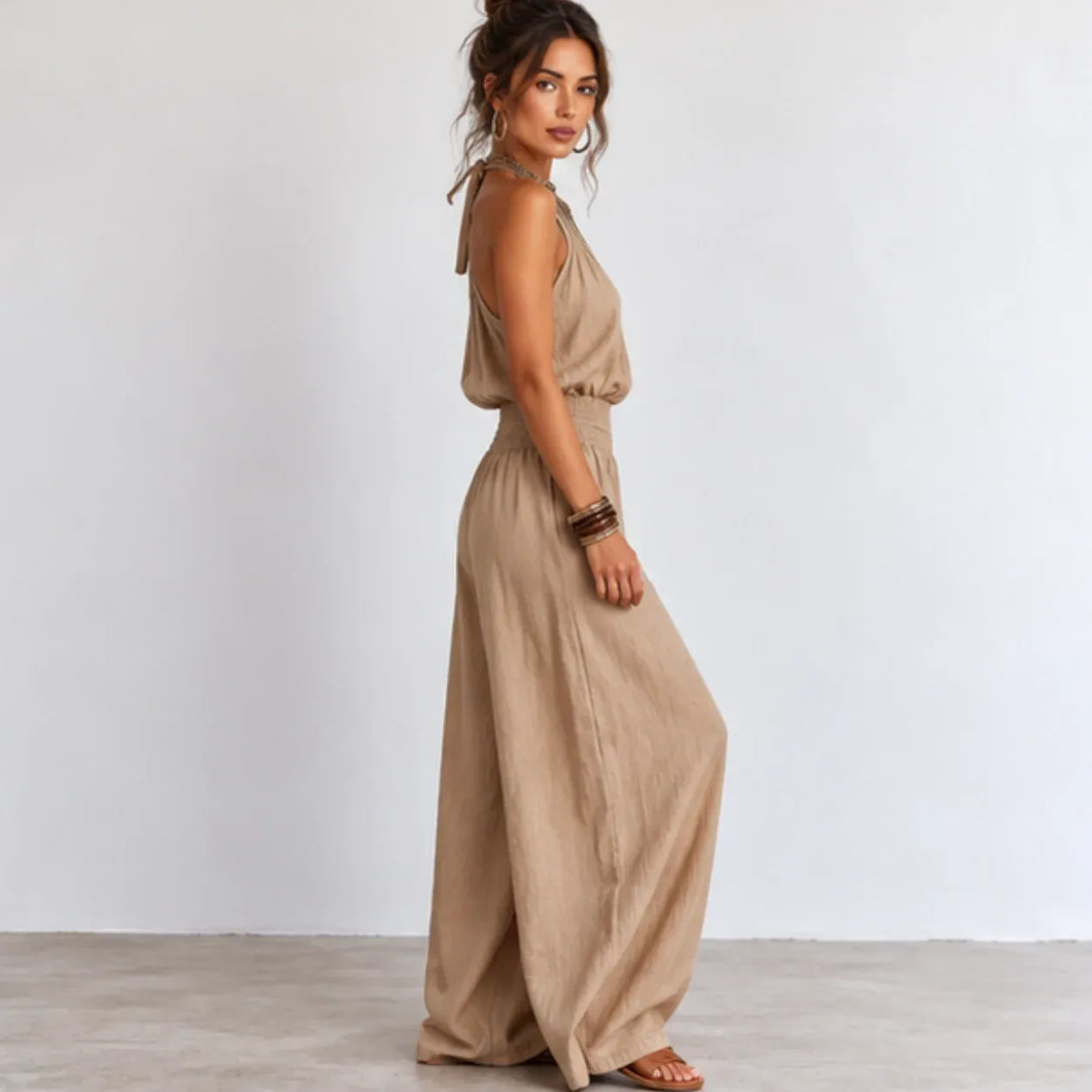 Side view of women’s khaki halter wide-leg linen jumpsuit with smocked waist