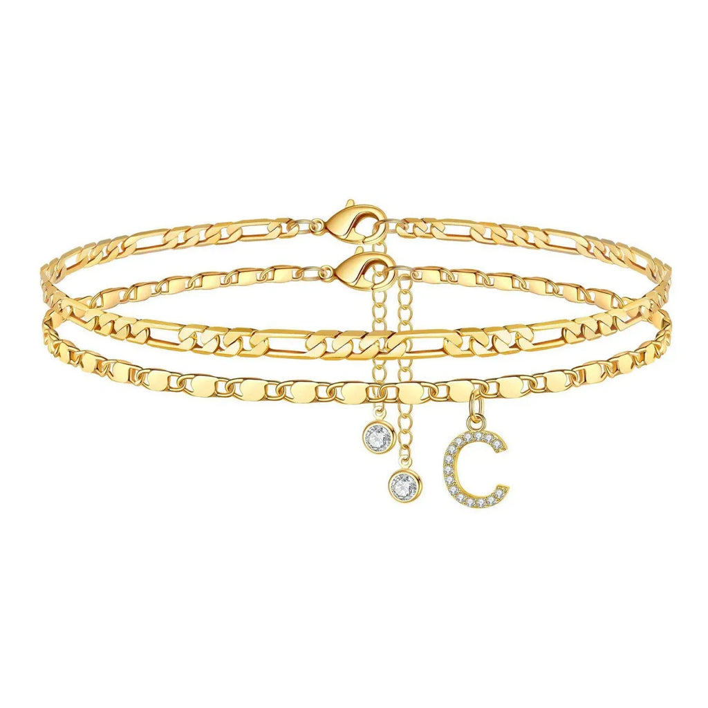Set of gold anklets with letter 'C' charm on a white background