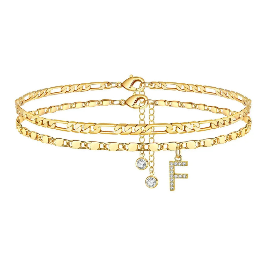 Set of gold anklets with letter 'F' charm on a white background