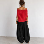 Back view of women’s red and black off-shoulder balloon pants two-piece set with relaxed flowing top