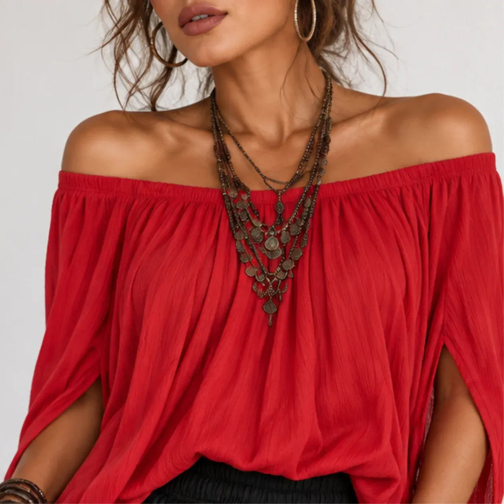 Close-up of women’s red off-shoulder top showing gathered neckline and flowing fabric details