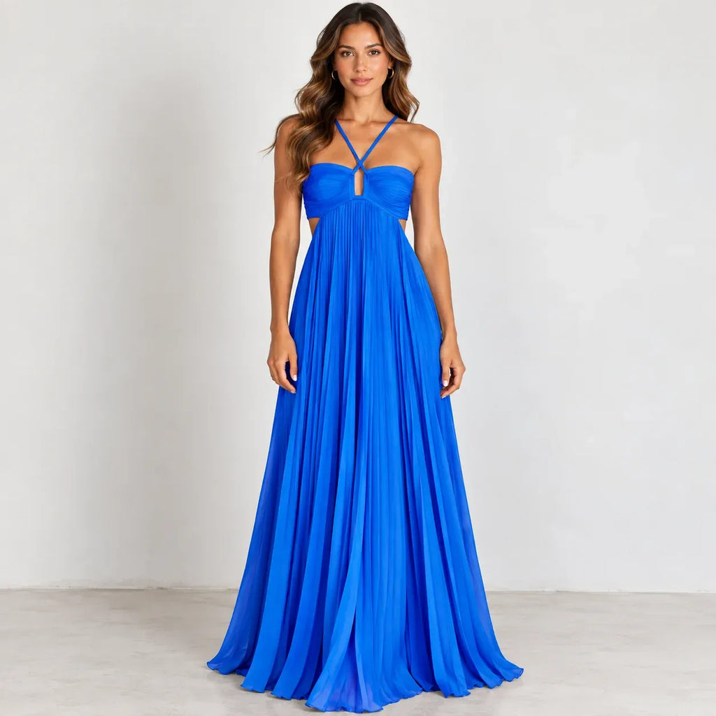 A woman modeling a bright royal blue floor-length gown with a halter-style neckline, front cutout detail, and flowing pleated skirt against a plain light gray studio background.