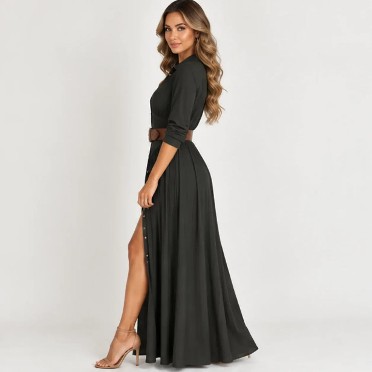 Side view of women’s black belted button-front long sleeve maxi dress with flowing pleated skirt and front slit