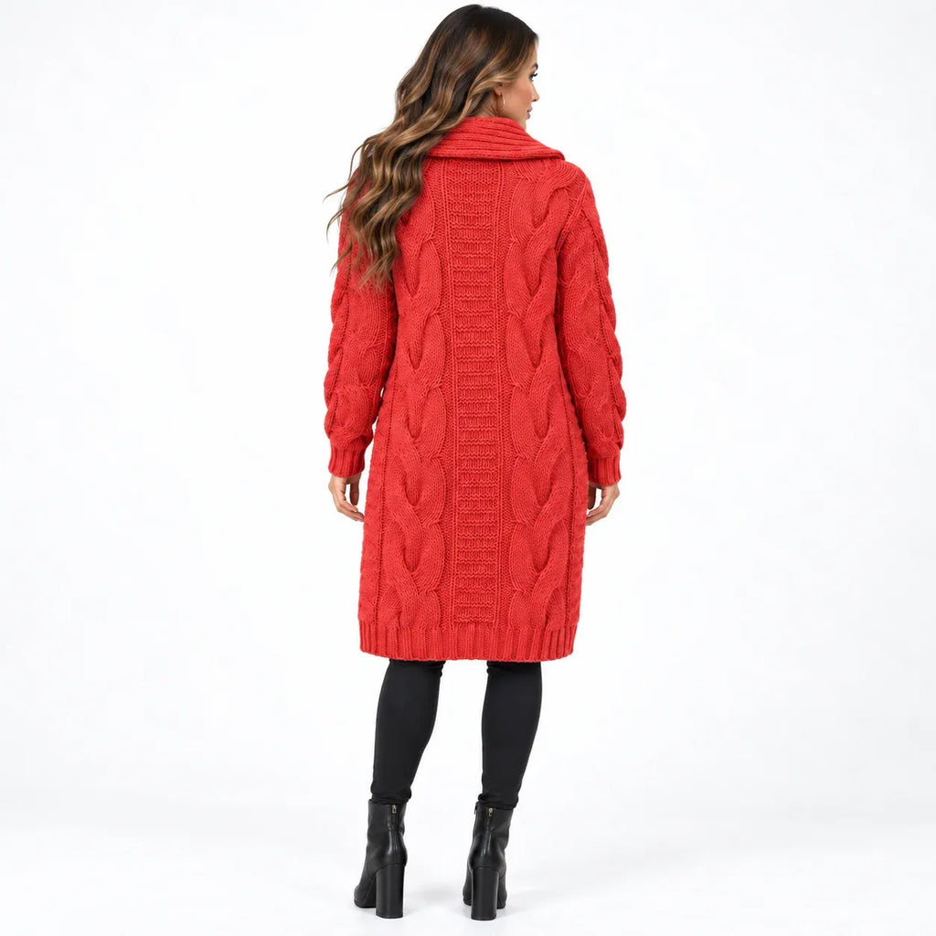 A woman viewed from the back wearing a bright red cable-knit long coat with a high collar, paired with black leggings and black ankle boots, against a plain white studio background.