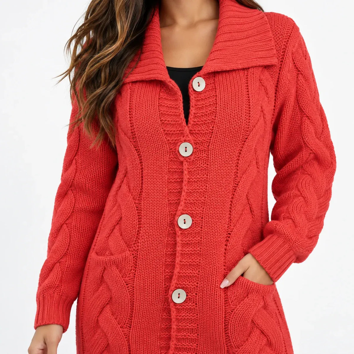 A woman wearing a red cable-knit cardigan sweater with a wide collar and large buttons, shown from the neck down against a plain white background.