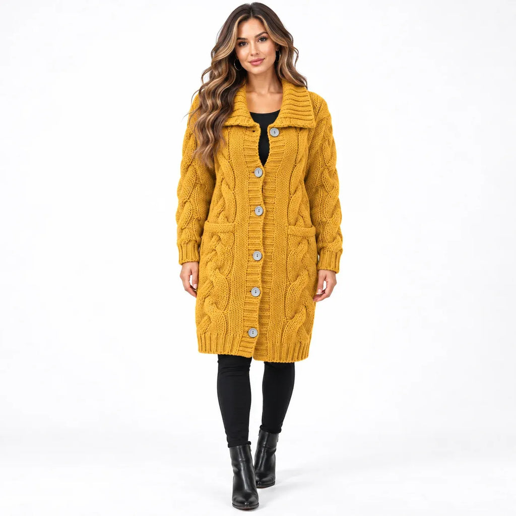 A woman modeling a mustard yellow cable-knit cardigan with silver buttons, worn over a black top and black leggings, against a plain white studio background.