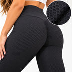Black high-waisted textured leggings shown on a model from the back, with a circular inset detail of the fabric texture.