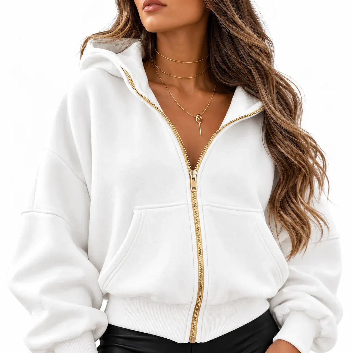 A woman wearing a white zip-up hoodie with a gold zipper and gold-toned necklace, cropped from the mouth down against a plain white background.