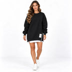 Black front: Model wearing a black sweater dress with long cuffed sleeves, a side zipper, and a white printed label.