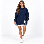 Navy blue front: Model wearing a navy blue long sleeve sweater dress with a side zipper and white printed label.