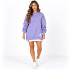 Purple front: Model wearing a purple long sleeve sweater dress with ribbed trim and a side zipper.