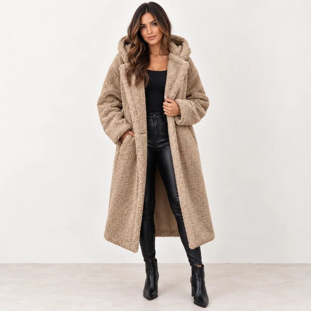 Apricot: Women's apricot longline teddy fleece coat with hood and wide lapels, styled with black pants and ankle boots.