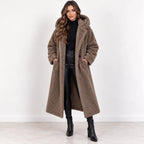 Khaki, front: Women's khaki longline teddy fleece coat with hood and front pockets, worn open over a black outfit.