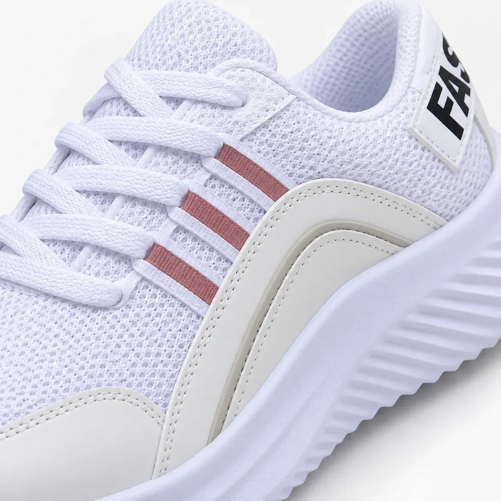 White athletic sneaker with white laces, three pink stripes on the side, and a thick white textured sole, shown in a close-up studio shot.
