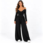 Black front: Model wearing a black off-shoulder wide-leg jumpsuit with a gathered bodice and long sleeves.