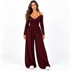 Burgundy front: Model wearing a burgundy off-shoulder wide-leg jumpsuit with long sleeves and a gathered bodice.