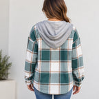 A woman viewed from the back wearing a green, white, and beige plaid hooded flannel shirt with a solid gray hood, paired with blue jeans.