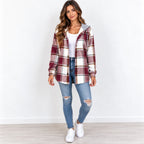 A woman modeling a long-sleeve hooded plaid shirt jacket in burgundy, cream, and gray, worn over a white t-shirt and blue ripped jeans with white sneakers.