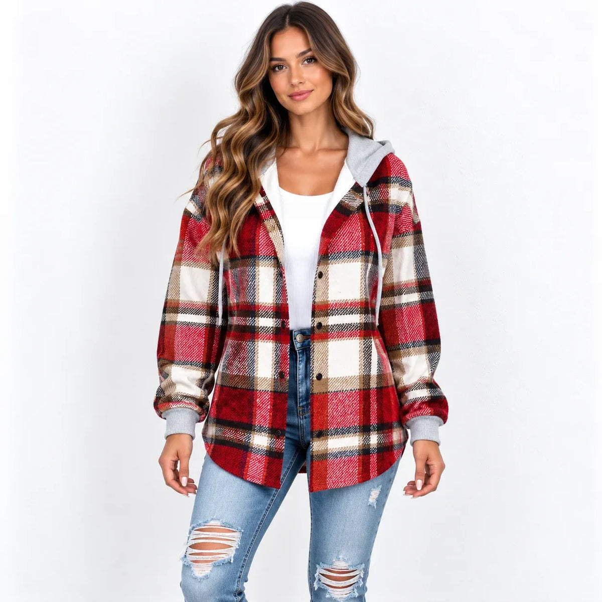 A woman modeling a red, beige, and black plaid hooded button-up jacket over a white top and distressed blue jeans, set against a plain white studio background.