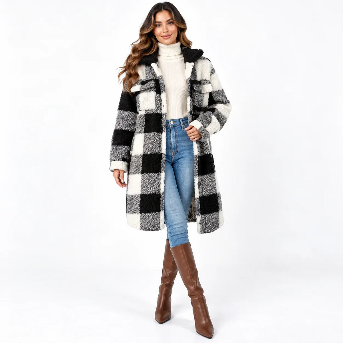 A woman modeling a black and white buffalo plaid faux fur coat with a black collar, styled with a cream turtleneck, blue jeans, and brown knee-high boots against a white studio background.