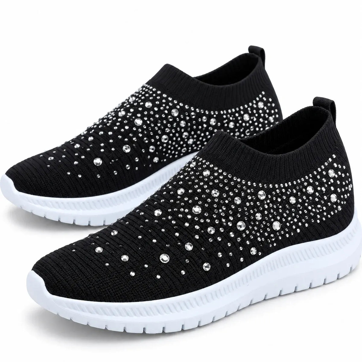 Black pair: Pair of black knit slip-on sneakers with rhinestone embellishments, ribbed openings, and white soles.