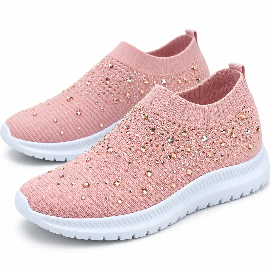 Pink pair: Pair of pink rhinestone knit slip-on sneakers with white soles and heel pull tabs.