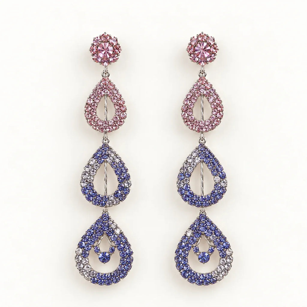 A pair of long teardrop dangle earrings with pink, blue, and purple rhinestone clusters on a white background.