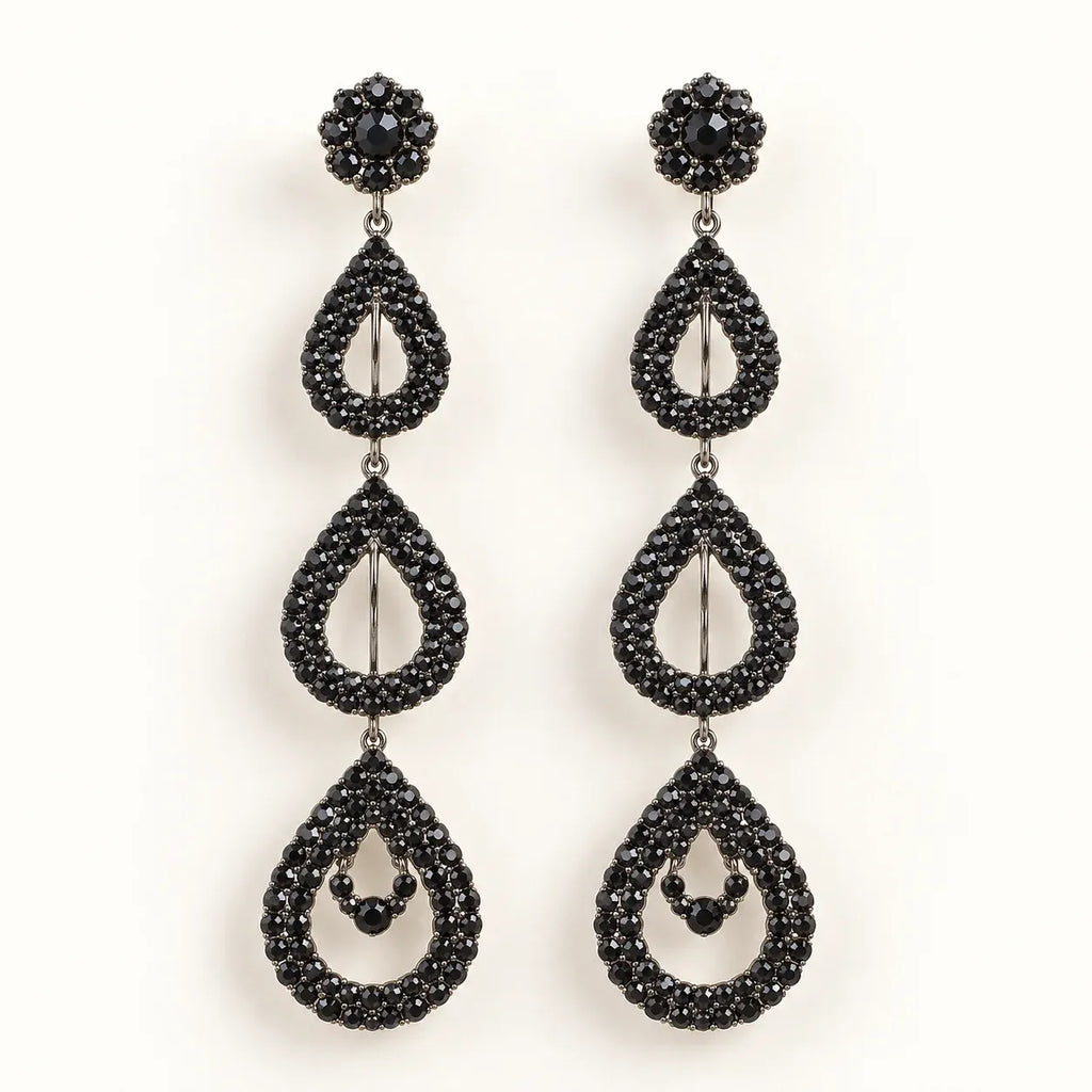 A pair of black teardrop dangle earrings with sparkling black rhinestones, featuring a floral stud top and three cascading teardrop drops on a clean white background.