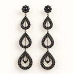 A pair of black teardrop dangle earrings with sparkling black rhinestones, featuring a floral stud top and three cascading teardrop drops on a clean white background.