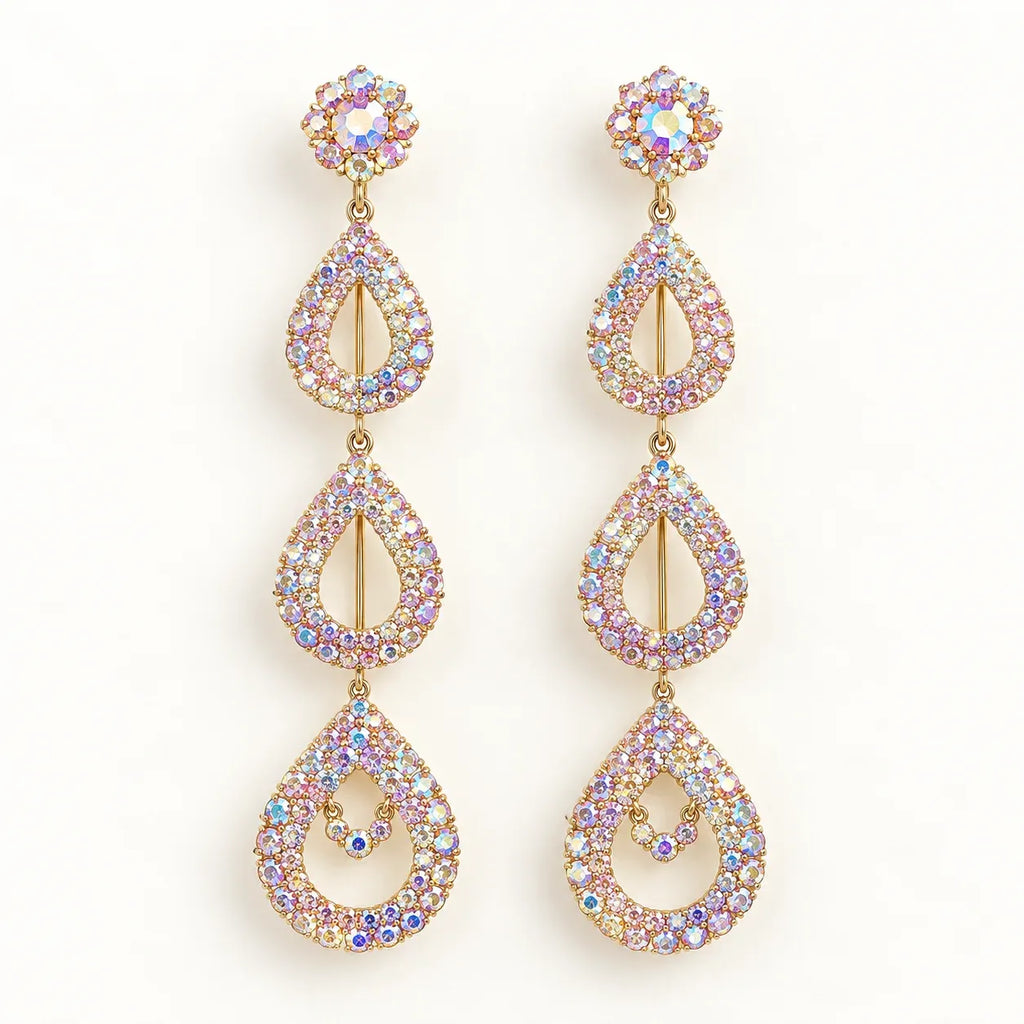 A pair of gold-tone dangle earrings adorned with iridescent, multi-colored rhinestones in a teardrop and floral design, set against a plain white background.