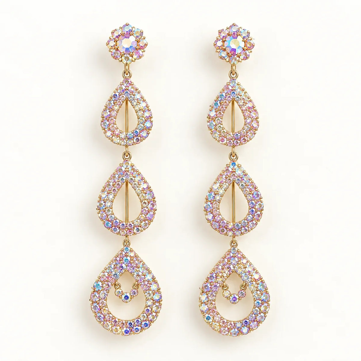 A pair of gold-tone dangle earrings adorned with iridescent, multi-colored rhinestones in a teardrop and floral design, set against a plain white background.