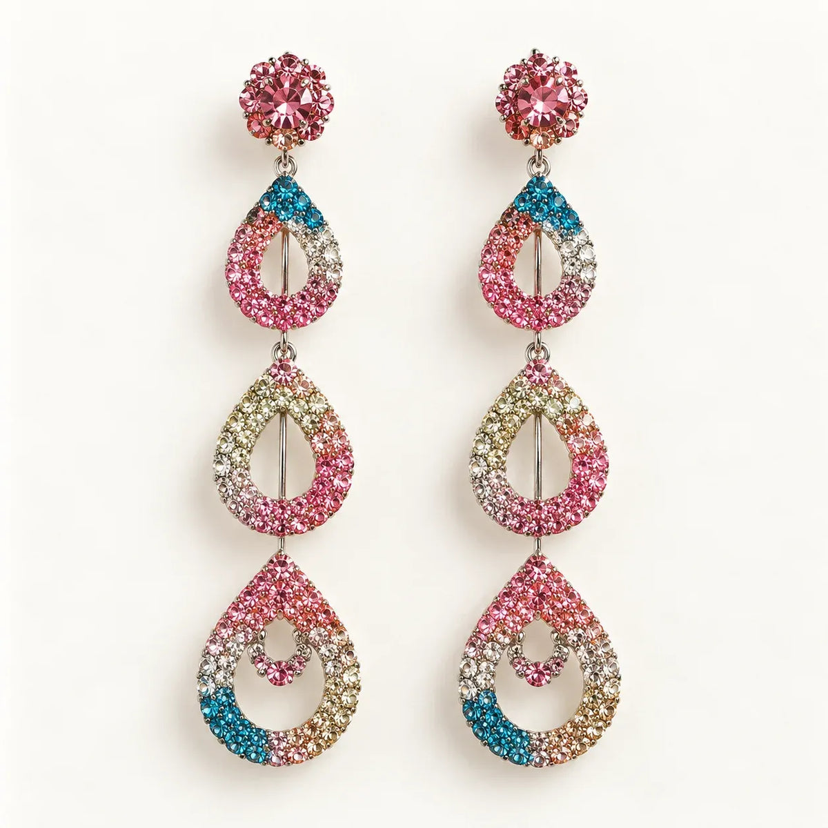 A pair of long dangling earrings with pink, blue, and gold teardrop-shaped crystal clusters on a plain white background.