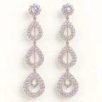 A pair of long drop earrings with a silver-tone metal setting and iridescent, rainbow-reflecting rhinestones, arranged vertically on a plain white background.