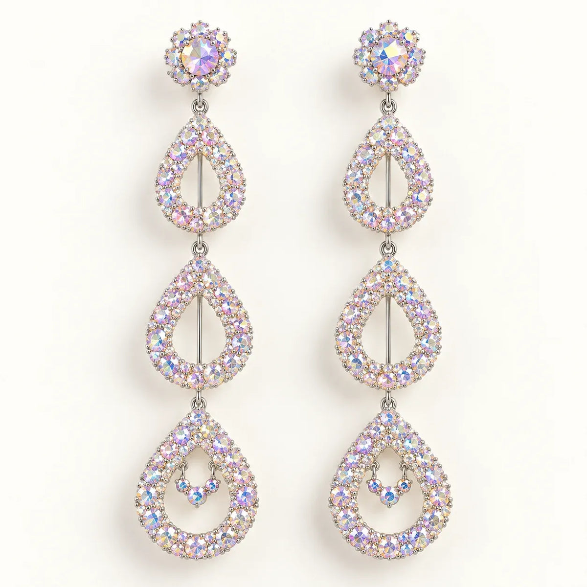 A pair of long drop earrings with a silver-tone metal setting and iridescent, rainbow-reflecting rhinestones, arranged vertically on a plain white background.