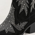 Black suede cowboy boot embellished with silver rhinestone western star patterns, shown on a light gray background.