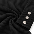 Close-up of a black ribbed knit garment, likely a sweater or jacket sleeve, with three round silver decorative buttons on the cuff against a white background.