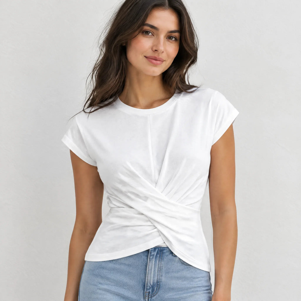A woman wearing a white short-sleeve t-shirt with a twisted knot detail at the front, paired with light blue jeans, against a light gray background.