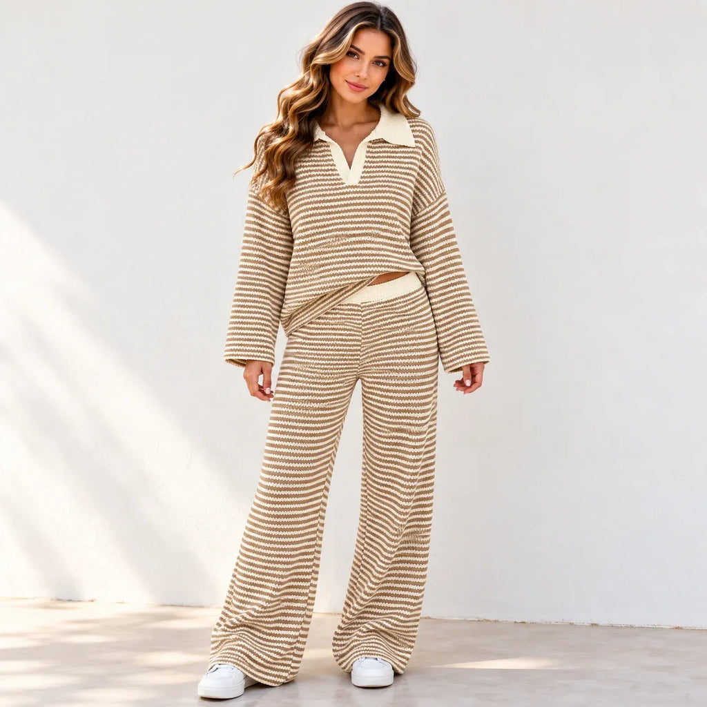 A woman front viewed wearing a matching khaki and white horizontally striped two-piece lounge set, walking outdoors against a white wall.