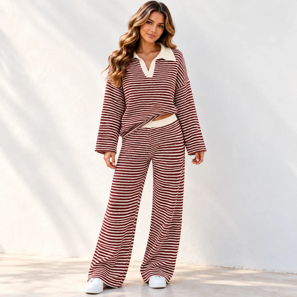A woman modeling a matching two-piece loungewear set with horizontal red and white stripes, featuring a long-sleeve collared top and wide-leg pants, standing against a white wall.