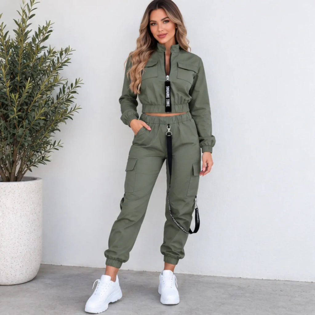 Women’s olive green utility jogger two-piece set with cropped zip jacket, cargo pockets, elastic jogger cuffs, and black strap details.